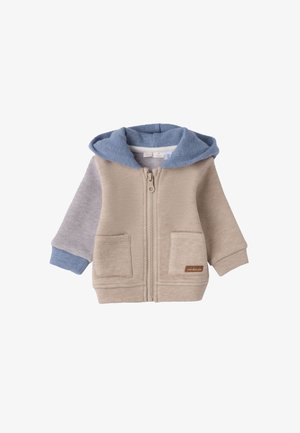 Haut à capuche beige pour tout-petits avec une capuche en polaire bleue, longues manches grises, deux poches avant et une fermeture éclair. Présente une petite étiquette marron.