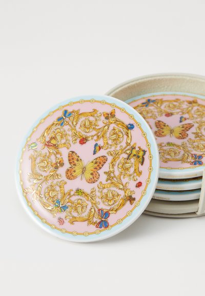 Sklop keramičnih podstavkov z rožnato podlago, z zlatimi cvetličnimi vzorci in metulji, z modrimi robovi in zapletenimi detajli.