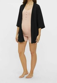 Svart kimono-liknande morgonrock med breda ärmar över en ljusrosa, ribbad tanktop och shorts-set, som visar upp en lager-på-lager, löst passande stil.