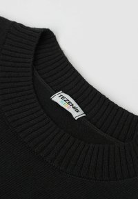 Černý pletený svetr s žebrovaným výstřihem a štítkem s nápisem "TEZENIS KIDS." Měkká textura s klasickým designem kulatého výstřihu.