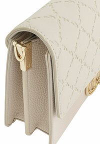 Biała skórzana torebka z pikowanym wzorem i złotymi akcentami. Posiada strukturalny kształt, zapięcie na klapkę oraz teksturowane wnętrze.