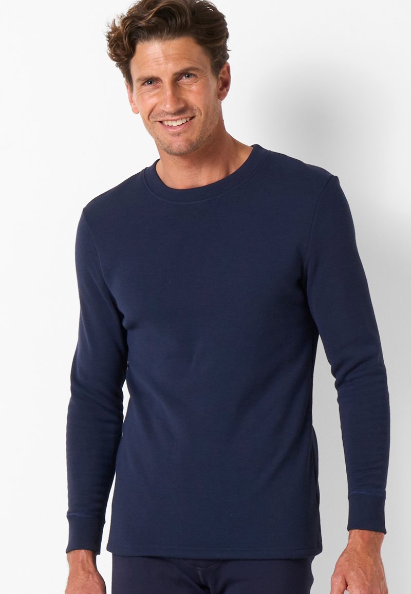 T-shirt a maniche lunghe blu navy realizzato in morbido cotone, con collo a giro e maniche con polsini, caratterizzato da una silhouette aderente e spacchi laterali.