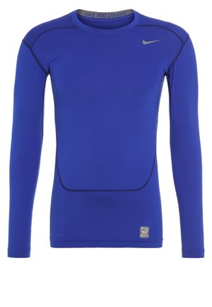 Blaues Nike Pro Combat Kompressionsshirt mit langen Ärmeln, grauem Swoosh-Logo auf der Brust und abgesteppten Nähten, die das Design betonen.