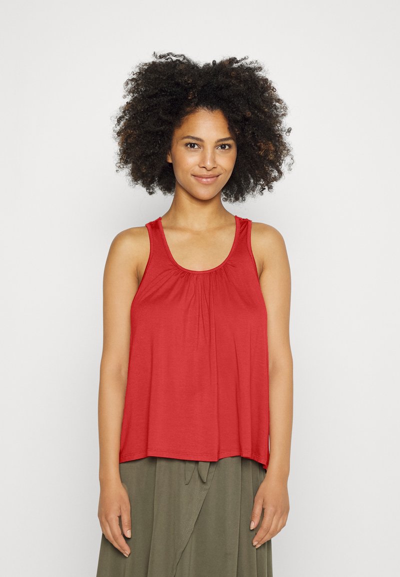 Camisola vermelha sem mangas com um corte descontraído, apresentando um decote franzido. Feita de um tecido macio, tem alças largas e uma bainha curva.