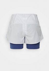 Vita New Balance löparshorts med blå inre kompressionstights, visade från baksidan på en enkel vit bakgrund.