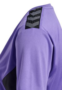 Camiseta deportiva morada con una textura suave, que presenta un panel negro estampado en el hombro y un diseño ajustado.