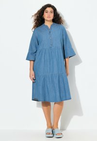 Denim midi-mekko, jossa on kolme neljänneshelmaa, pyöristetty kaula-aukko, nappilista ja kerroksellinen hame. Vaaleansininen väri, sileä rakenne.