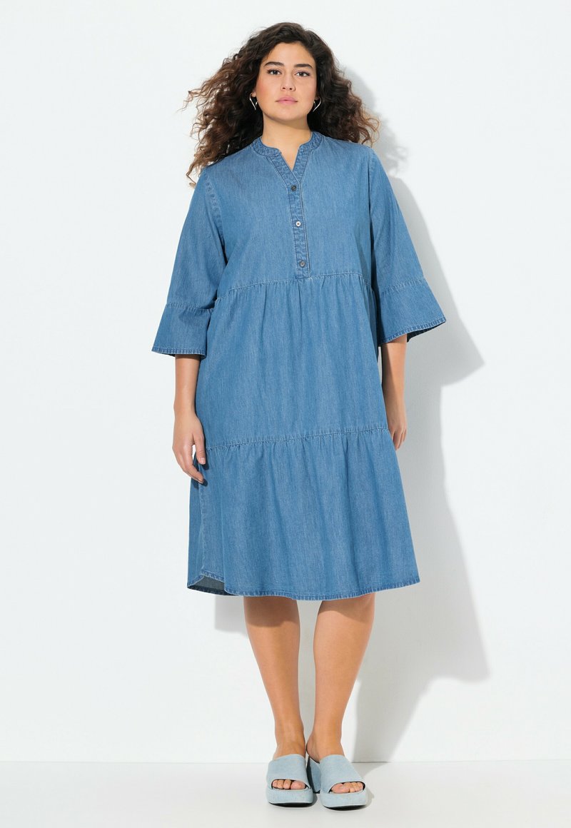 Denim midi-mekko, jossa on kolme neljänneshelmaa, pyöristetty kaula-aukko, nappilista ja kerroksellinen hame. Vaaleansininen väri, sileä rakenne.