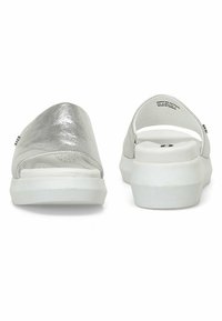 Zilveren instapsandalen met een gladde metallic afwerking, open achterkant, witte gevoerde zool en geperforeerde voetbed voor comfort.