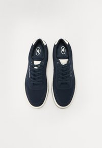 Mørkeblå sneakers med teksturert mesh-overdel, hvite detaljer, og snøring med logo på tungen og forsterket tå.