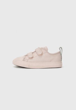 Baskets en toile roses avec deux bandes Velcro, bout arrondi, semelle en caoutchouc légère et une petite languette grise à l'arrière.