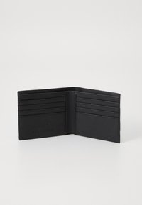Svart skinnlommebok med flere kortlommer, en glatt tekstur og syede kanter. Innvendig har den et enkelt design uten pynt.