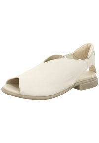 Bílé kožené sandály na otevřenou špičku s nízkým podpatkem, které mají měkkou texturu, výřezový design a elastický pásek pro bezpečné uchycení.