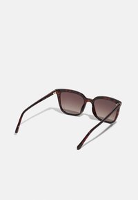 Schildpatt-Sonnenbrille mit quadratischem Rahmen, Verlaufsgläsern, schlanken Bügeln und goldenen Hardware-Akzenten an den Scharnieren.