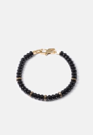 Black beaded bracelet featuring hexagonal beads, interspersed with gold accents and a gold clasp, showcasing a sleek and textured design.