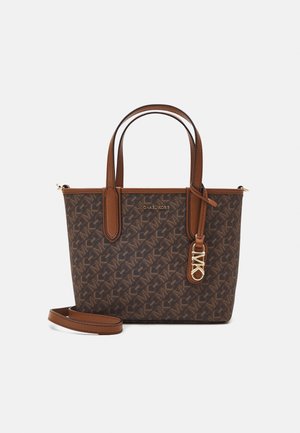Sac cabas marron à motifs avec double anses, bandoulière amovible et breloque logo dorée sur le devant.