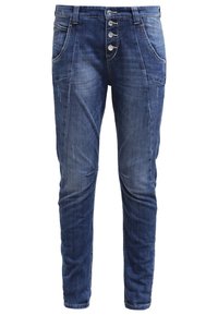 Jeans dżinsowe w ciemnoniebieskim kolorze, o zwężanym kroju i zapięciu na pięć guzików. Posiadają kieszenie z przodu oraz subtelny, wyblakły wzór.