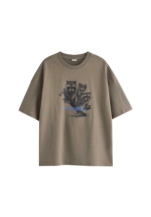 Brun oversized T-shirt med en grafik af tre vaskebjørne, der kører på skateboard, og blå tekst på forsiden.