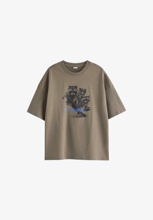 Brun oversized T-shirt med en grafik af tre vaskebjørne, der kører på skateboard, og blå tekst på forsiden.