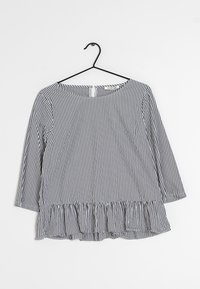 Randig långärmad topp i marinblått och vitt. Har en rund halsringning och en volangkant. Tillverkad av ett lätt tyg med en slät textur.