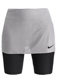 Falda de malla gris con pantalones cortos integrados en negro; presenta el logo de Nike en negro en la parte inferior derecha. Tejido suave y transpirable.