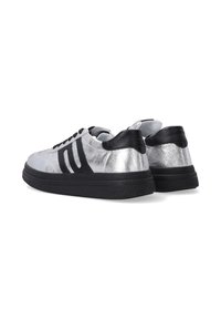 Silberne Sneaker mit schwarzen Akzenten, ausgestattet mit einem glatten Lederobermaterial, runder Zehenform und dicker Gummisohle. Schnürung vorne, minimalistisches Design.