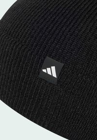 Černá pletená čepice s ribovanou strukturou a obdélníkovou černou nášivkou s bílým logem zobrazujícím tři bílé trojúhelníky.