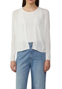 Weißer leichter Cardigan mit langen Ärmeln, offenem Frontdesign, leicht verkürztem Saum, getragen über einem hellen, eng anliegenden Oberteil und blauen Jeans.
