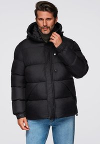 Chaqueta negra acolchada con capucha, que cuenta con cierre de cremallera y a presión, bolsillos laterales y puños acanalados. La tela parece suave y brillante.
