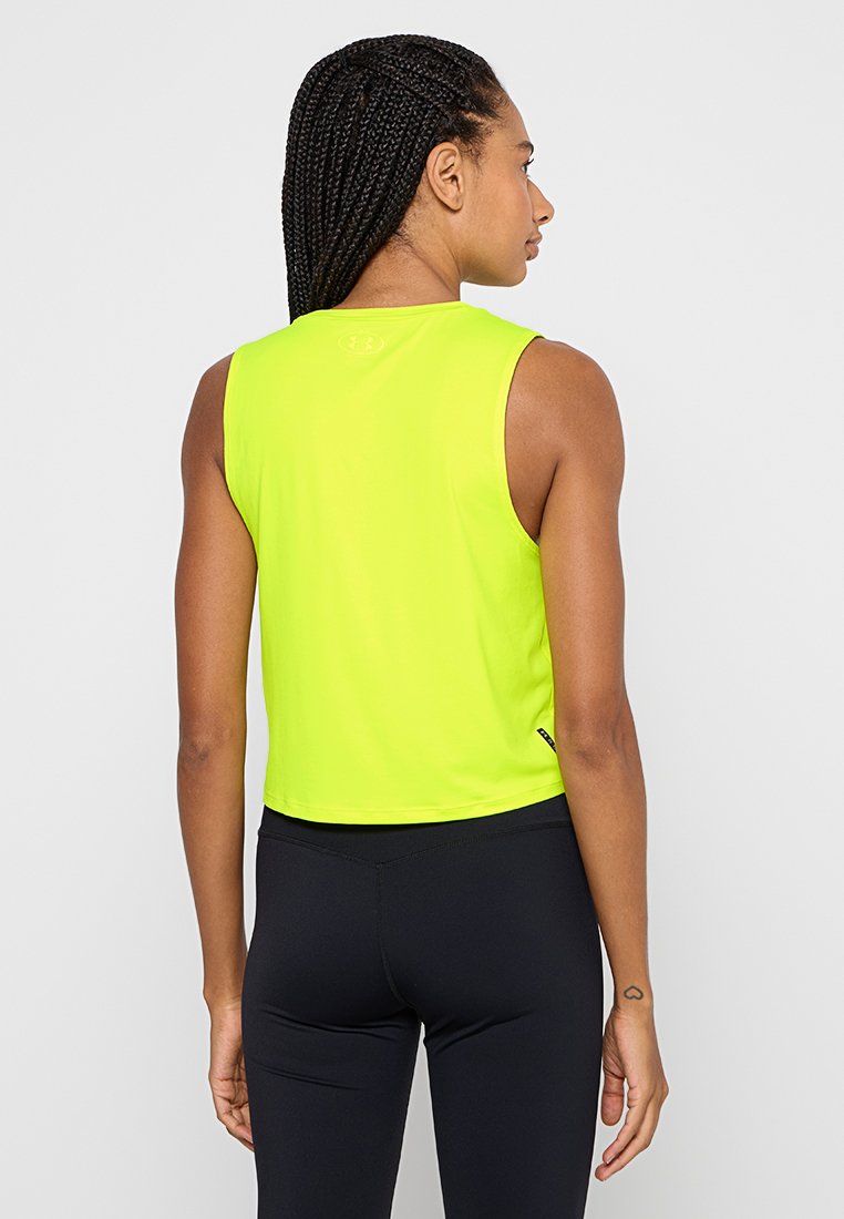 Top deportivo corto sin mangas en amarillo neón con textura suave, escote redondo y logo en la parte posterior, combinado con leggings negros.