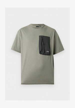 T-shirt vert olive à manches courtes avec une grande poche zippée noire sur la poitrine gauche, étiquetée "TAION MOUNTAIN WEAR".
