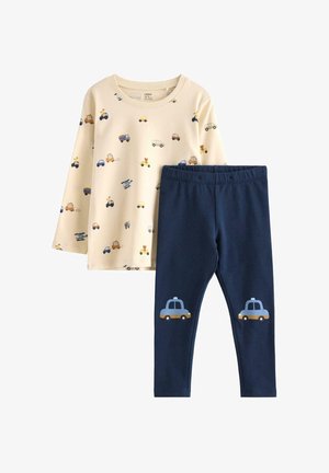 Světle béžová košile s dlouhým rukávem a potisky vozidel; tmavě modré legíny s grafickými prvky taxíků na kolenou. Měkký bavlněný materiál, ležérní design.