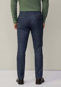 Marineblauwe, slim fit broek met een geruit patroon, gemaakt van textuurstof, met twee achterzakken met knoopsluitingen en ceintuurlussen.