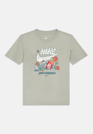 Camiseta de algodón verde claro con un gráfico colorido que incluye un logo de Nike con forma de nube, flores y equipo deportivo. Manga corta, cuello redondo.