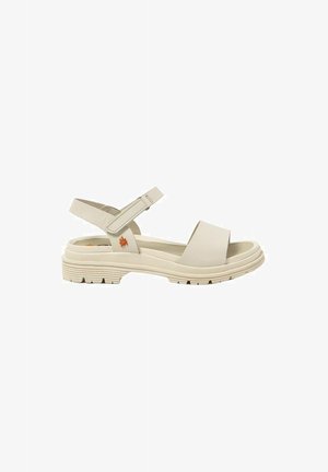 Sandal de un beige claro con una banda ancha y una correa ajustable en el tobillo. Presenta una suela texturizada con ranuras y un pequeño acento floral en color naranja.