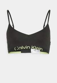 Bralette nera con spalline sottili e regolabili, scollatura a V e banda con logo Calvin Klein verde lime a contrasto lungo l'orlo. Tessuto dalla texture liscia.