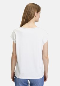 White short-sleeve t-shirt with a round neckline and slight drop shoulder. Smooth texture, relaxed fit, and visible stitching detail.