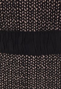 Tissu à motif géométrique noir et beige avec une bande plissée noire horizontale au centre.