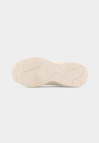 Semelle de basket beige avec des motifs géométriques et la marque "Tommy Hilfiger" embossée près du talon.