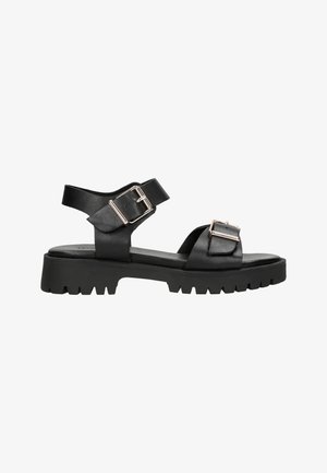 Zwarte leren sandalen met verstelbare gespsluitingen, een platte zool en een robuuste, gestructureerde buitenzool. Eenvoudig ontwerp met minimale accenten.