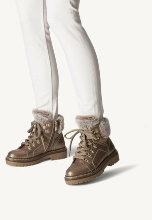 Bottines en bronze avec des poignets en fausse fourrure, en cuir texturé, avec des lacets et des fermetures éclair sur les côtés ; conçues avec des semelles robustes pour une meilleure adhérence.