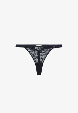 String en dentelle noire avec des motifs floraux élaborés, des bretelles fines et des accents en métal doré. Design semi-transparent.