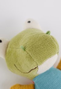 Soft plush toy with a green textured head, cream ears, and a blue body. Features black eyes and small green accents on the head.