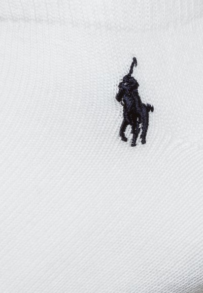 Chaussette en coton blanc avec un logo noir brodé représentant un cheval et un cavalier. Texture lisse avec un design côtelé.
