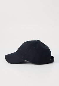 Nav blå kasket lavet af bomuld, med en buet skygge, justerbar rem bagpå og diskret broderet detaljering foran.