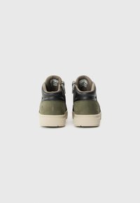 High-top sneakers with a black leather upper, olive green suede accents, beige lining, and side zippers. Elevated rubber outsole.
