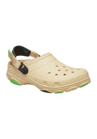 Beige klipklapper med ventilationshuller, blødt foer og en bagrem. Har grønne og sorte accenter på sålen, lavet af slidstærkt materiale.