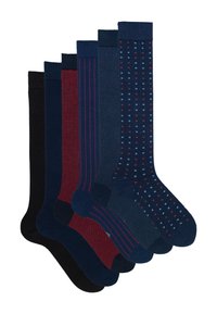 Zes paar herenlang sokken in zwart, marineblauw, rood en blauw met effen, gestreepte, gevlekte en vierkante patronen, gerangschikt in een waaiervorm.