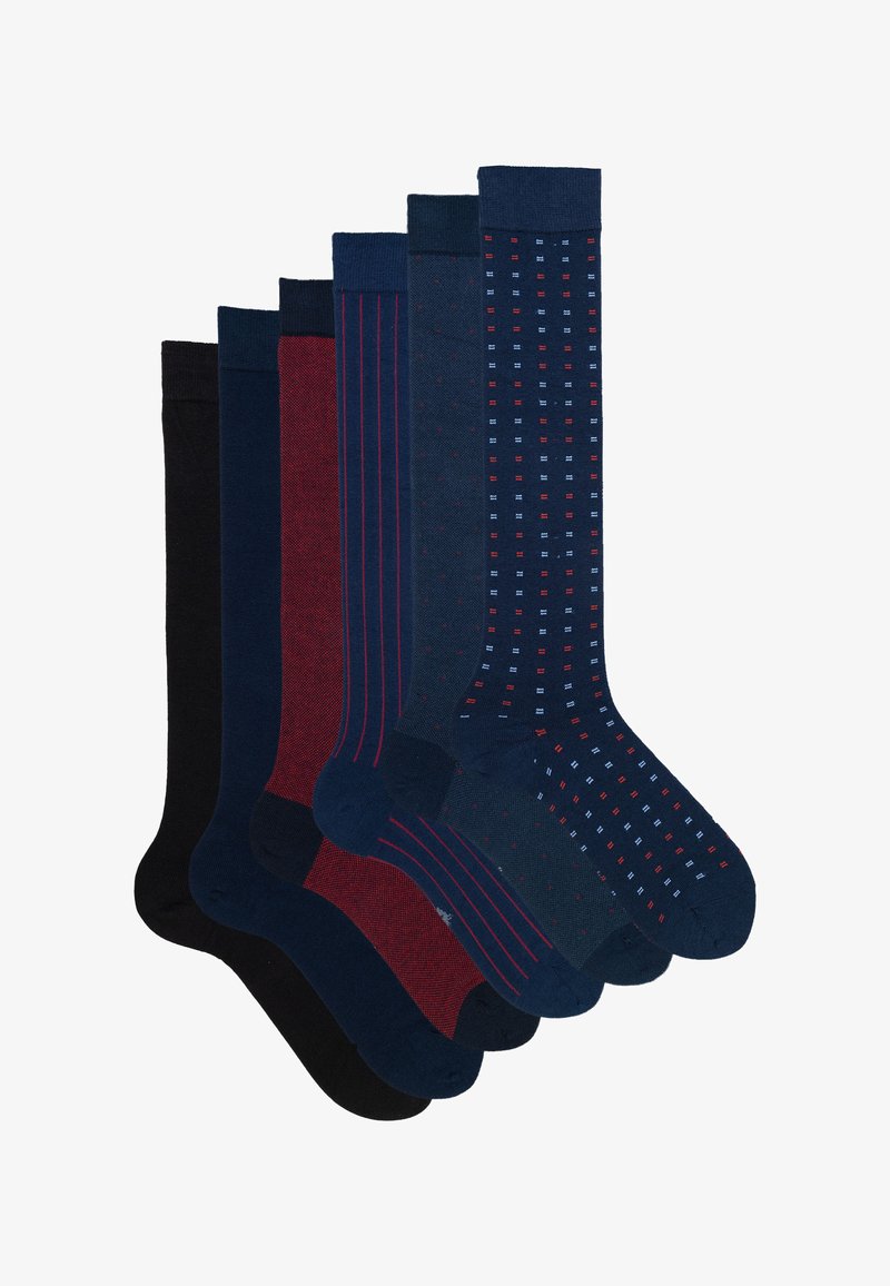 Zes paar herenlang sokken in zwart, marineblauw, rood en blauw met effen, gestreepte, gevlekte en vierkante patronen, gerangschikt in een waaiervorm.