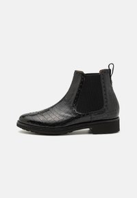 Stivaletto Chelsea in pelle nera con texture a coccodrillo, pannelli laterali elasticizzati e un tacco basso a blocco. Presenta una linguetta sul retro e cuciture dettagliate.